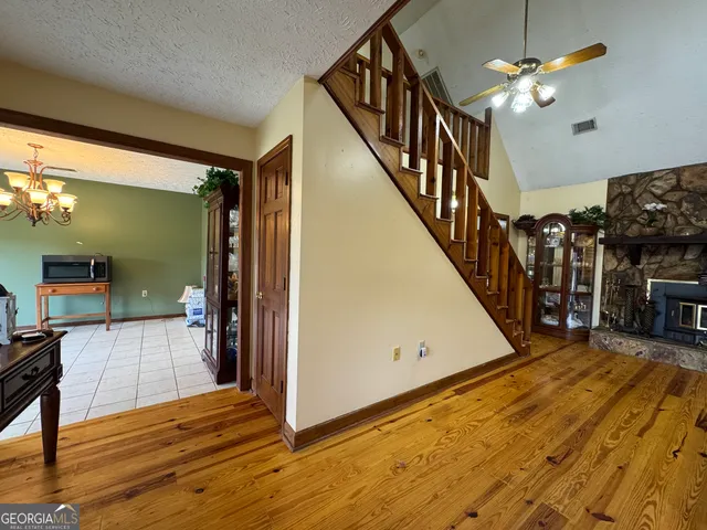 a living room with furniture a fireplace a flat screen tv and windows