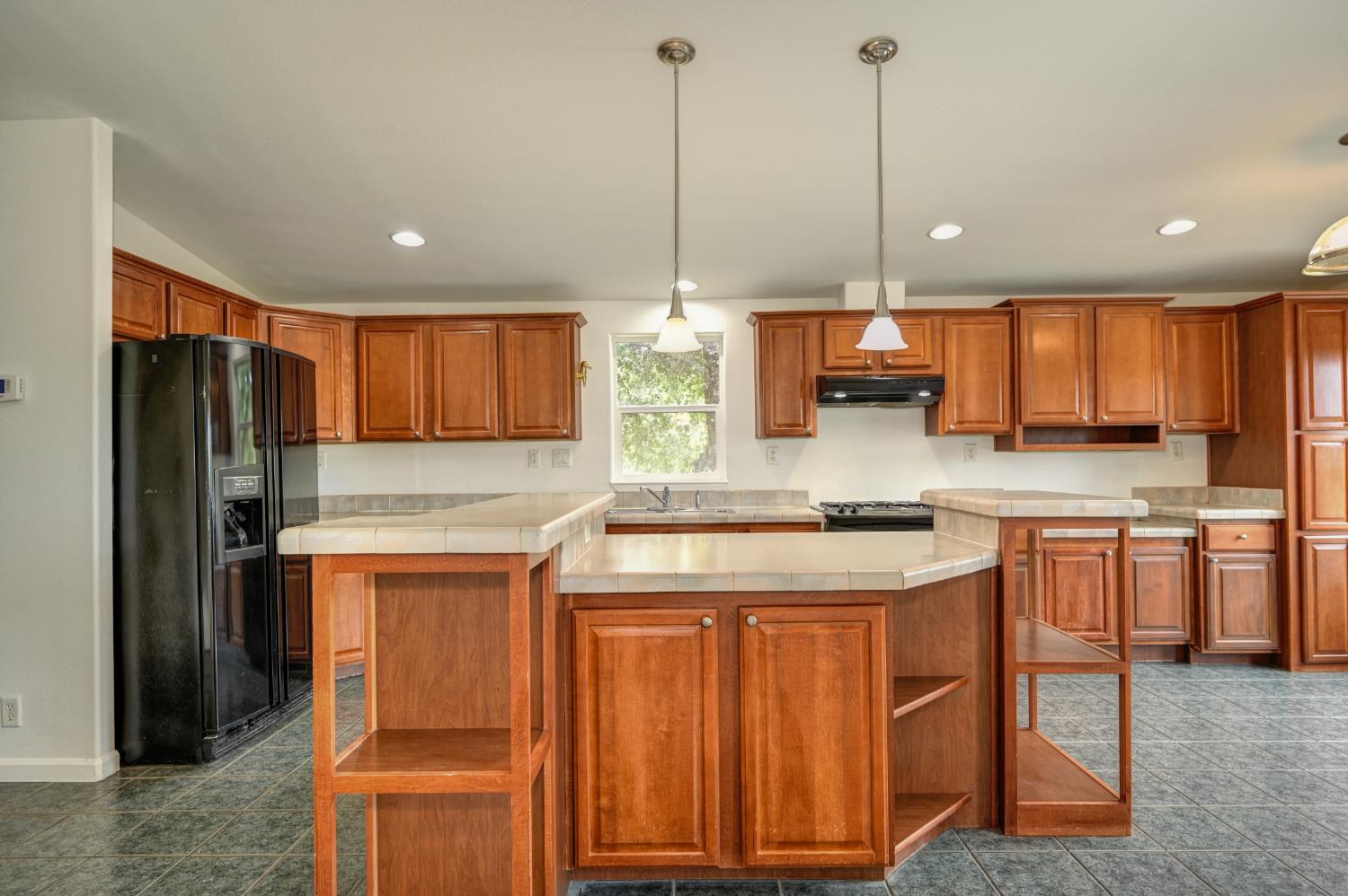 3680 Greenwood Road Garden Valley, CA 95633 - Photo 4 of 32 a kitchen with stainless steel appliances granite countertop wooden cabinets a sink a stove a refrigerator and island