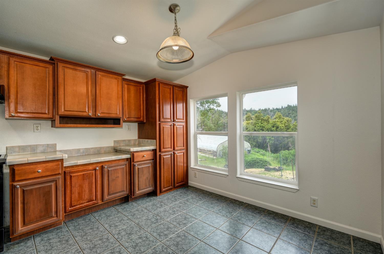 3680 Greenwood Road Garden Valley, CA 95633 - Photo 5 of 32 a view of a kitchen with stainless steel appliances granite countertop a stove a sink dishwasher and a refrigerator with wooden cabinets