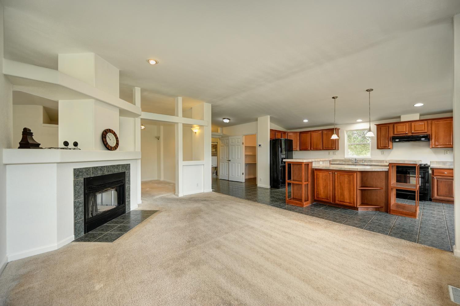 3680 Greenwood Road Garden Valley, CA 95633 - Photo 7 of 32 a view of a kitchen with a fireplace and cabinets