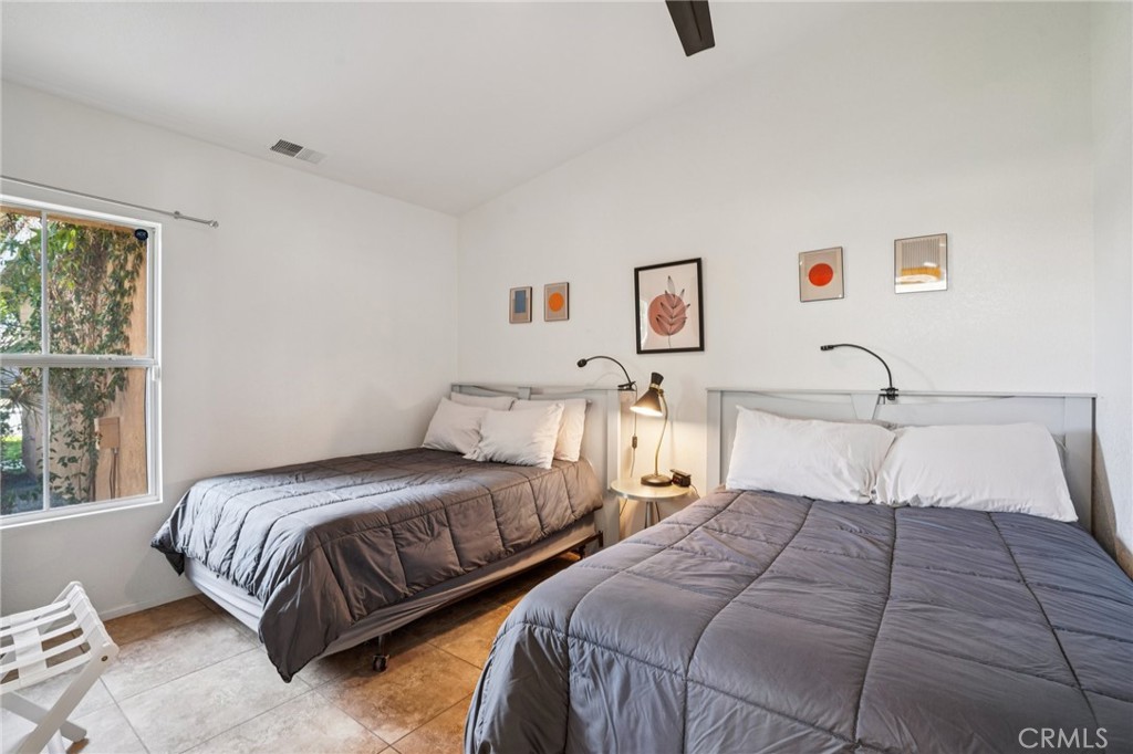 83290 Mango Walk Indio, CA 92201 - Photo 12 of 31 a bedroom with two beds and painting on the wall