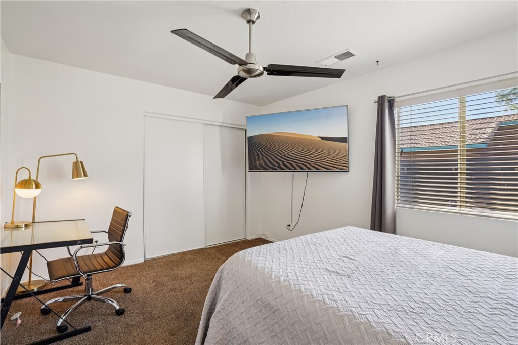 83290 Mango Walk Indio, CA 92201 - Photo 14 of 31 a bedroom with a bed a desk and chair