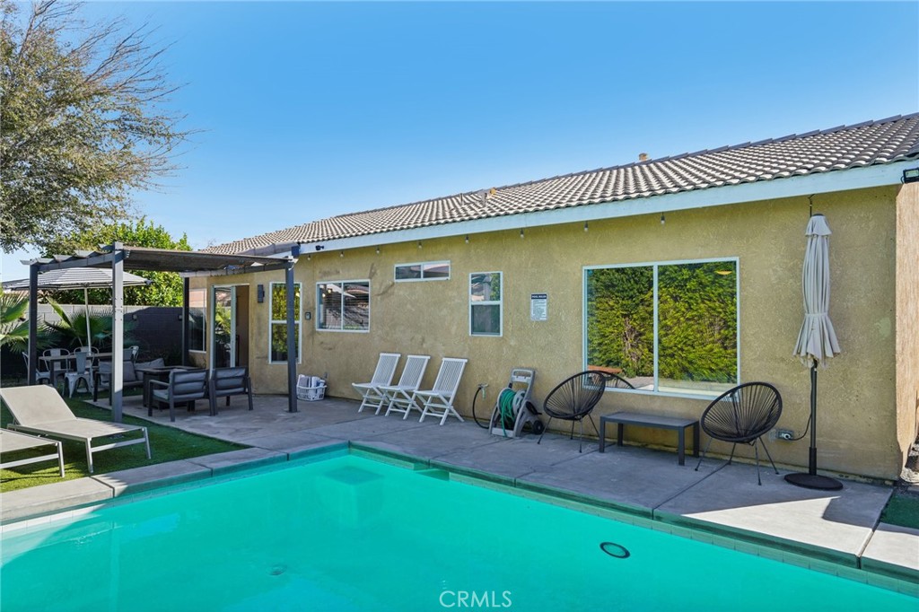 83290 Mango Walk Indio, CA 92201 - Photo 18 of 31 a view of a patio with table and chairs with wooden fence