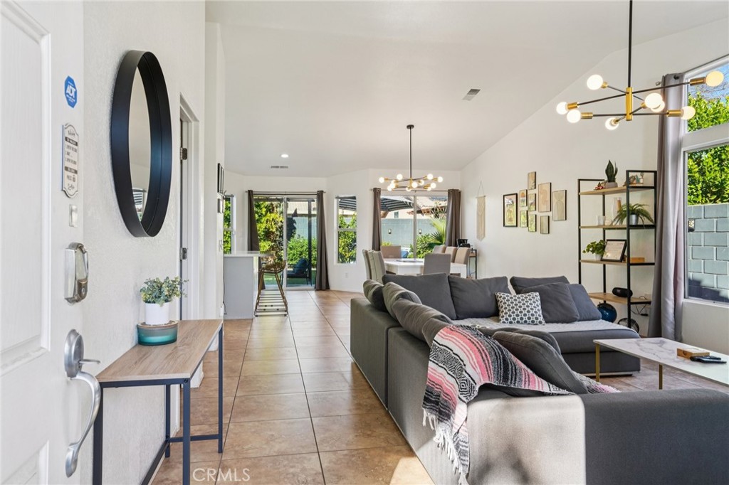 83290 Mango Walk Indio, CA 92201 - Photo 3 of 31 a living room with furniture and a chandelier