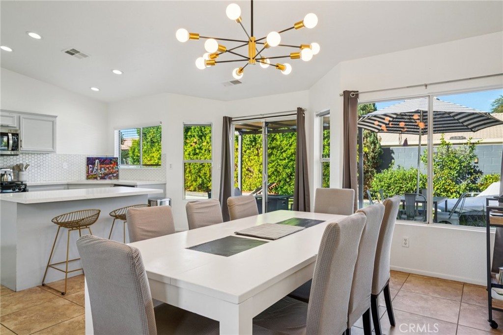 83290 Mango Walk Indio, CA 92201 - Photo 5 of 31 a view of a dining room with furniture a chandelier and wooden floor