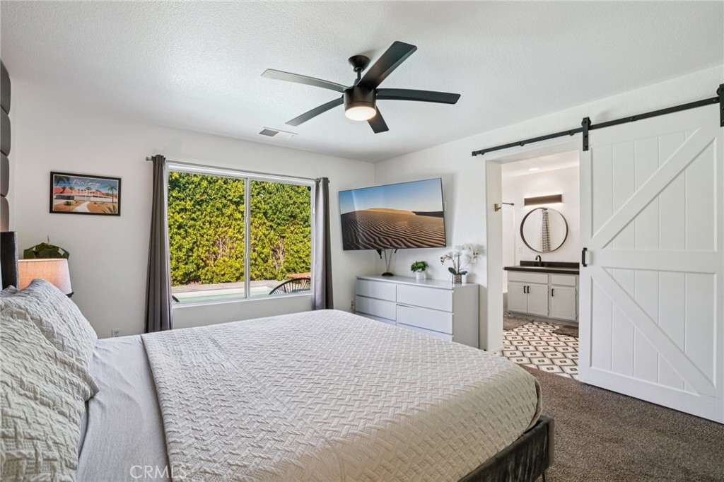 83290 Mango Walk Indio, CA 92201 - Photo 10 of 31 a bedroom with a bed and a flat screen tv