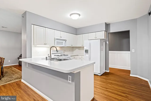 a kitchen with a sink a refrigerator and cabinets