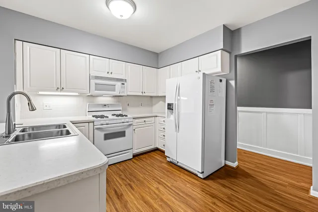 a kitchen with a refrigerator sink and cabinets
