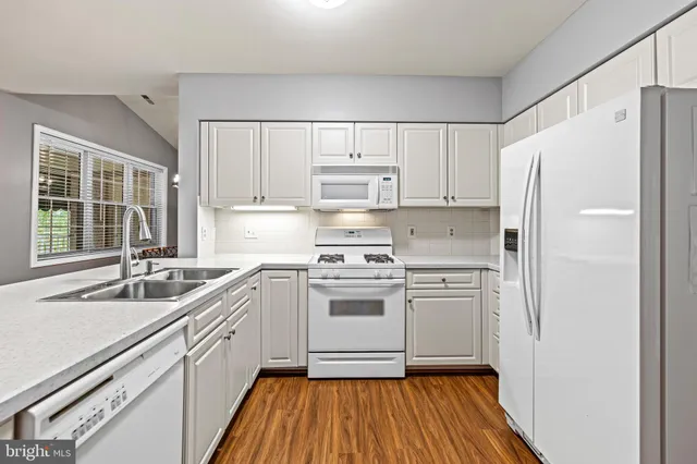 a kitchen with white cabinets sink and white appliances