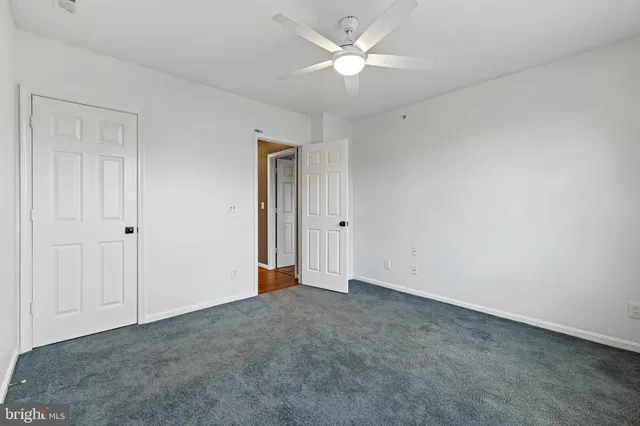 an empty room with a ceiling fan and a window