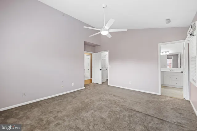an empty room with a ceiling fan and a fan