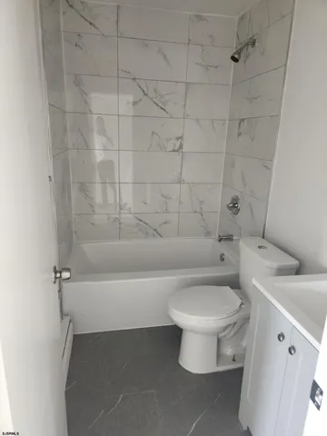 a white toilet sitting next to a bath tub