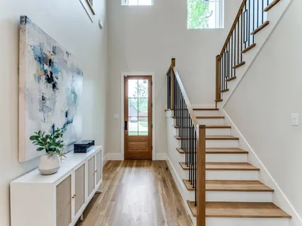 a view of a hallway with wooden floor and stairs