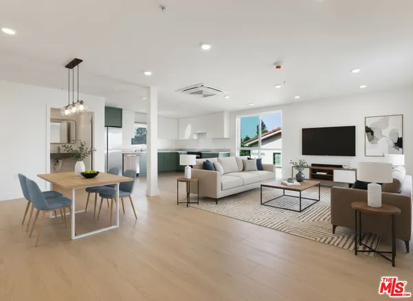 a living room with furniture kitchen view and a flat screen tv