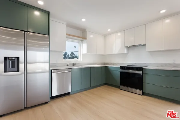 a kitchen with granite countertop a sink and stainless steel appliances