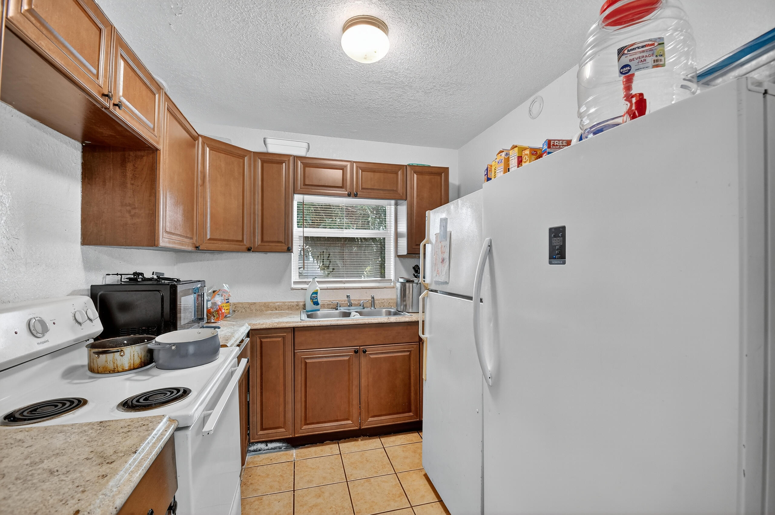 173 West 18th Street Riviera Beach, FL 33404 - Photo 11 of 28 a kitchen with a sink a stove and refrigerator