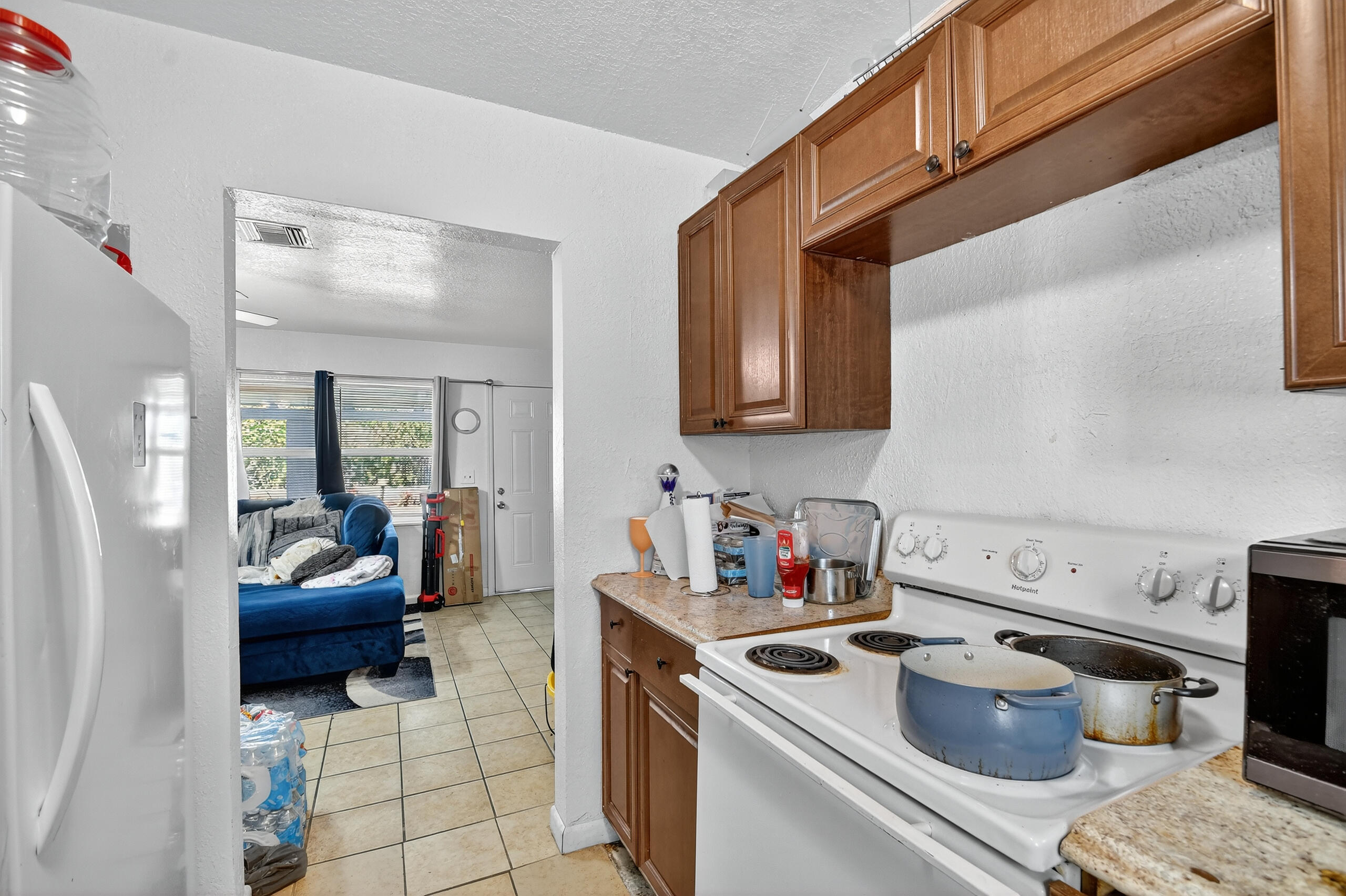 173 West 18th Street Riviera Beach, FL 33404 - Photo 12 of 28 a kitchen with a sink and dishwasher a stove with wooden cabinets