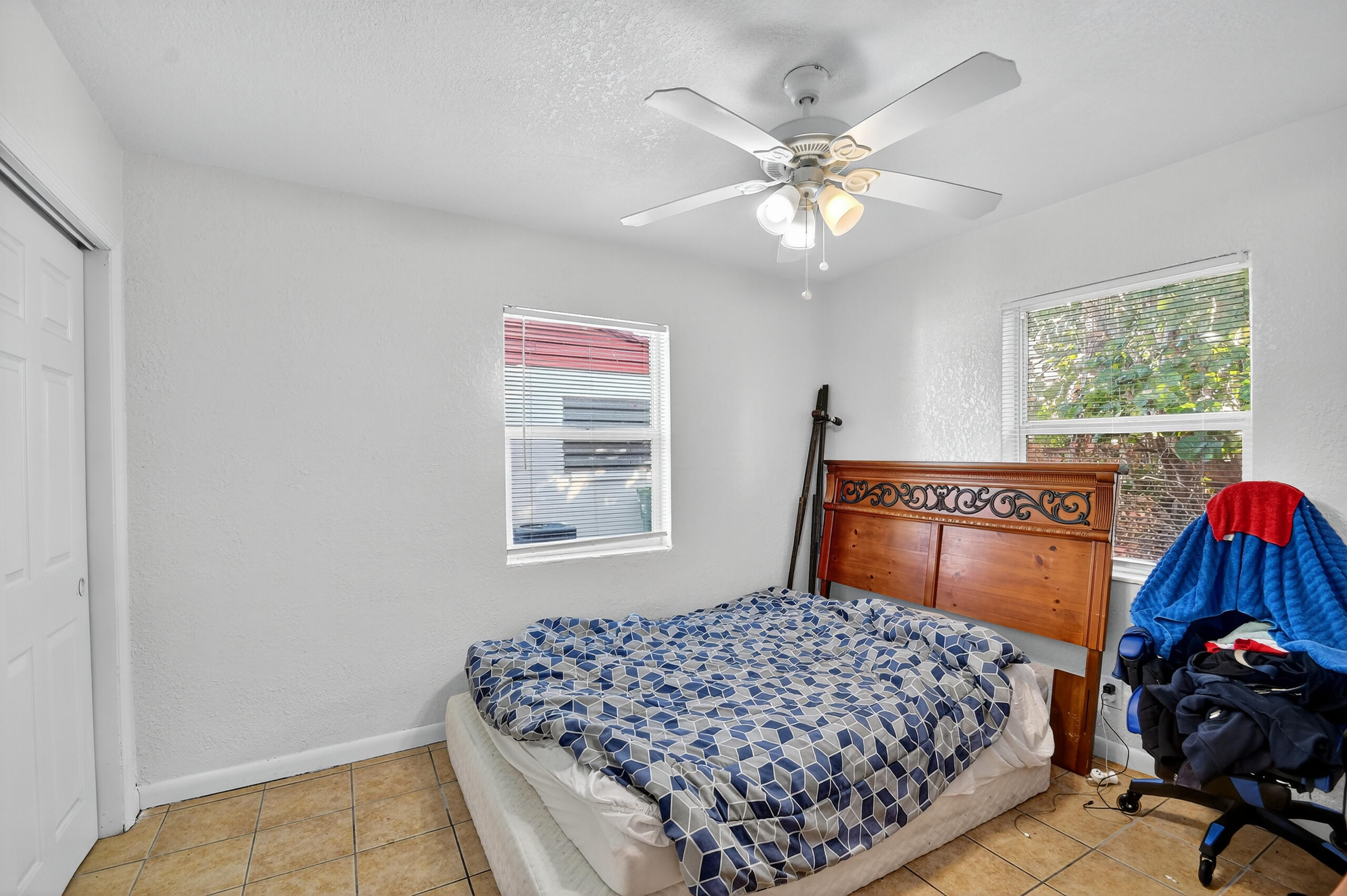 173 West 18th Street Riviera Beach, FL 33404 - Photo 16 of 28 a bedroom with a bed and a chandelier
