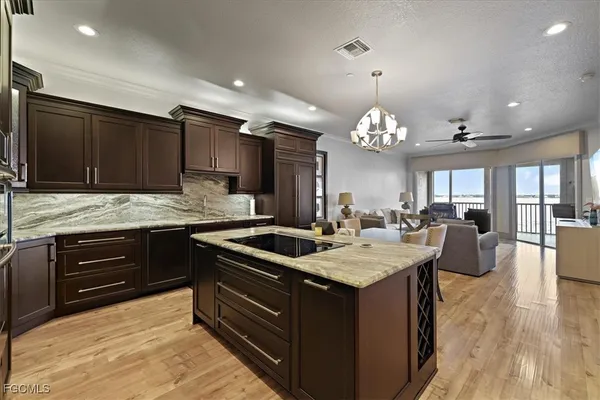 a kitchen with granite countertop a sink stove and cabinets