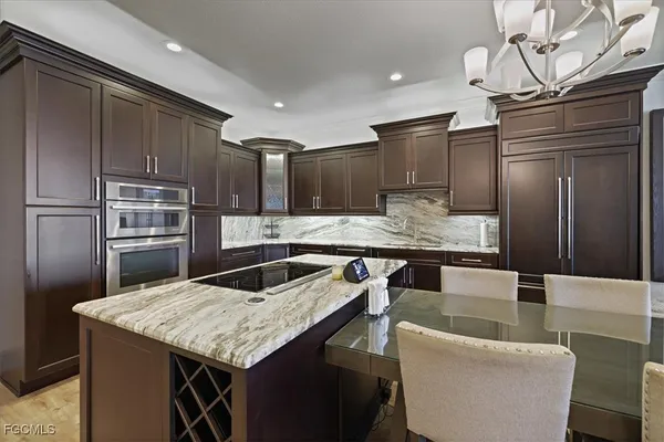a kitchen with stainless steel appliances granite countertop a sink refrigerator and cabinets