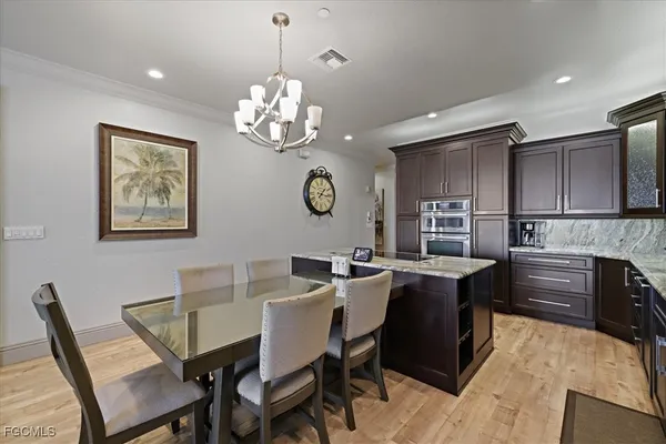 a view of a dining room with furniture a chandelier and wooden floor