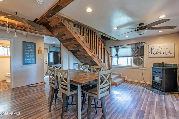 a dining room with wooden floor a chandelier a wooden table and chairs
