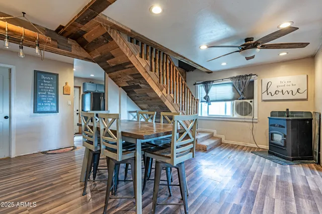 a dining room with wooden floor a chandelier a wooden table and chairs