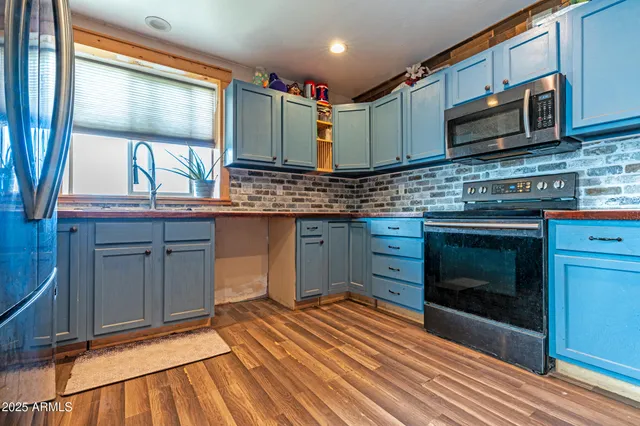 a kitchen with stainless steel appliances granite countertop a stove a sink and a microwave