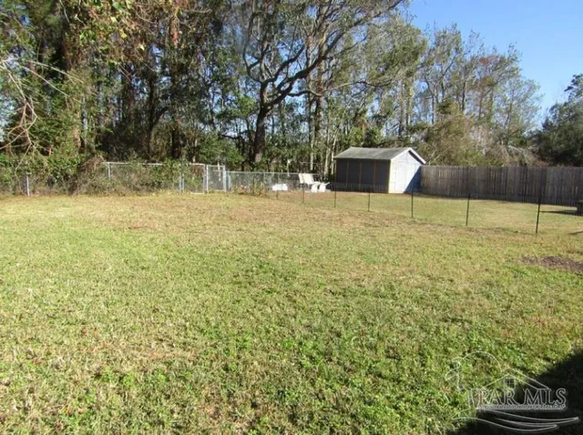 a backyard of a house with a yard and tree