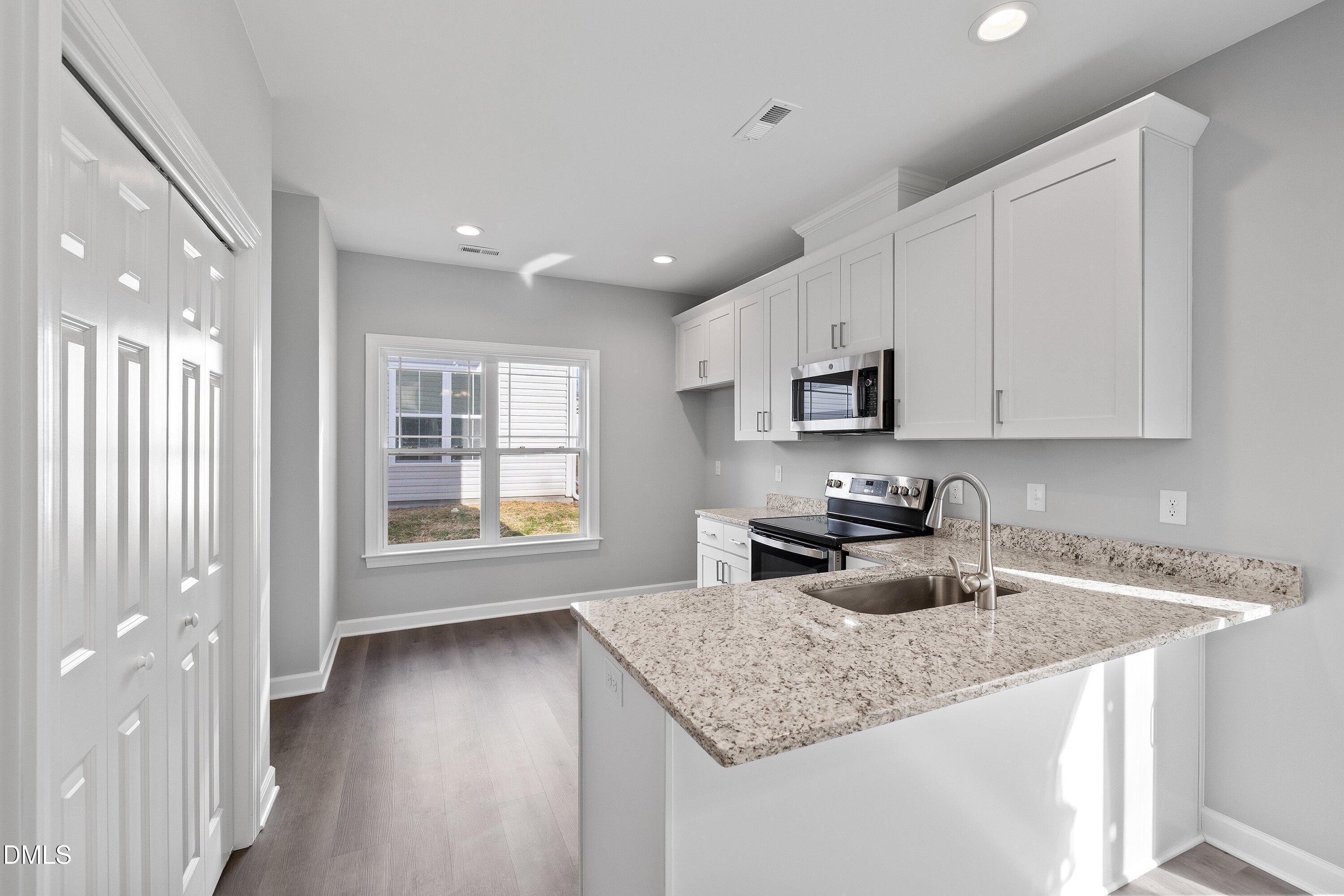 1804 Falls Landing Drive Raleigh, NC 27614 - Photo 11 of 20 a kitchen with stainless steel appliances granite countertop a sink stove and cabinets