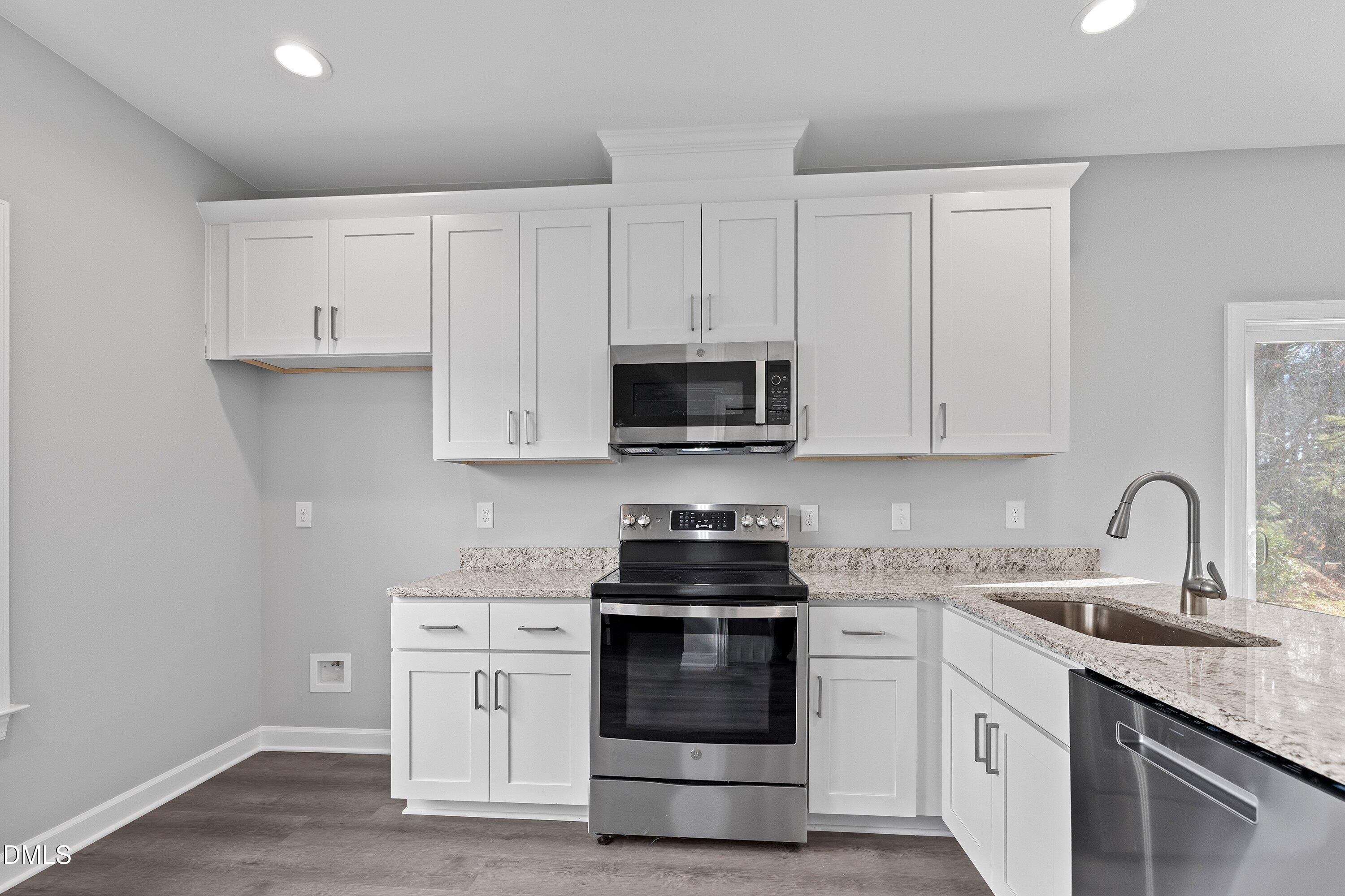 1804 Falls Landing Drive Raleigh, NC 27614 - Photo 12 of 20 a kitchen with white cabinets and stainless steel appliances