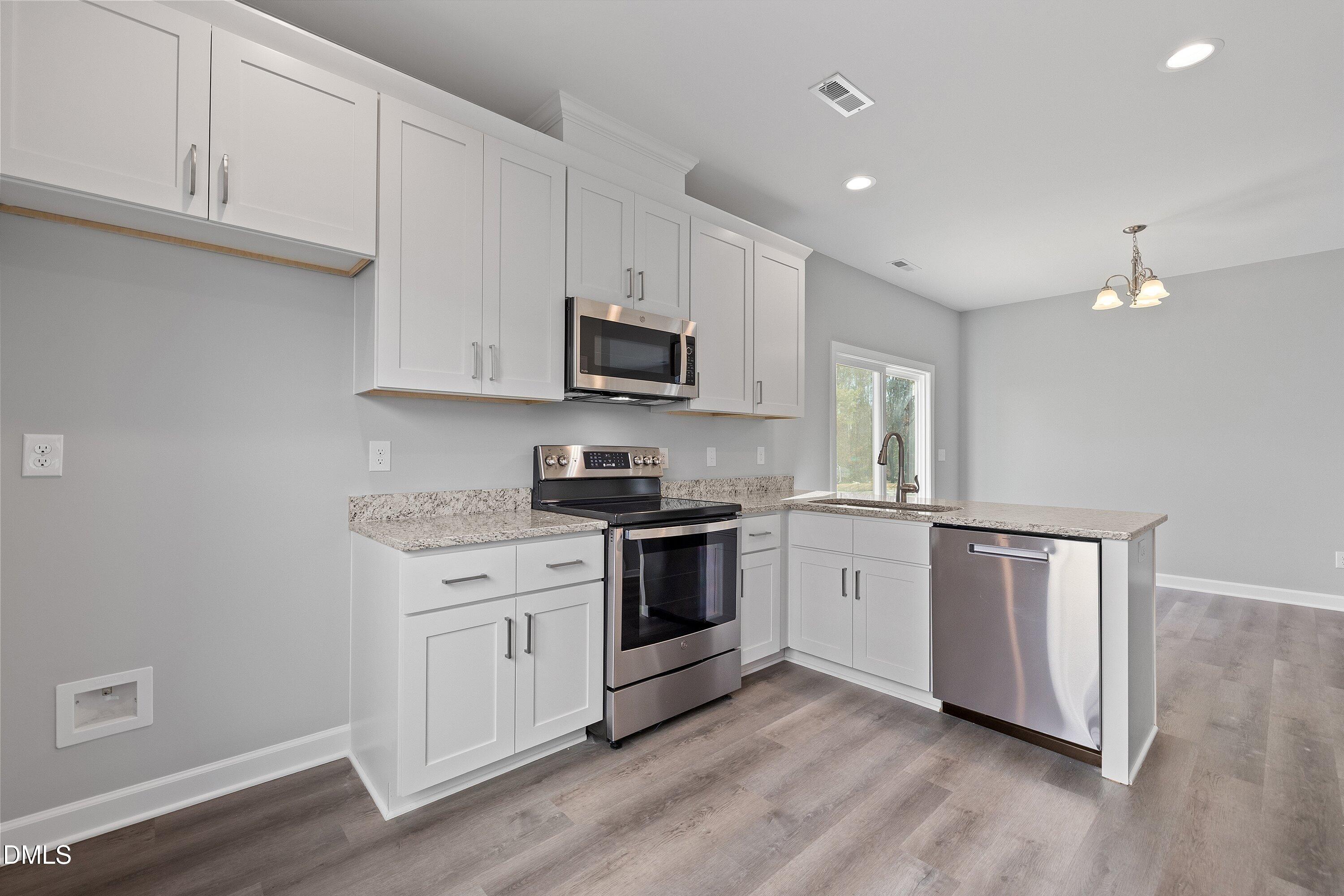 1804 Falls Landing Drive Raleigh, NC 27614 - Photo 13 of 20 a kitchen with stainless steel appliances granite countertop a stove a sink and a microwave