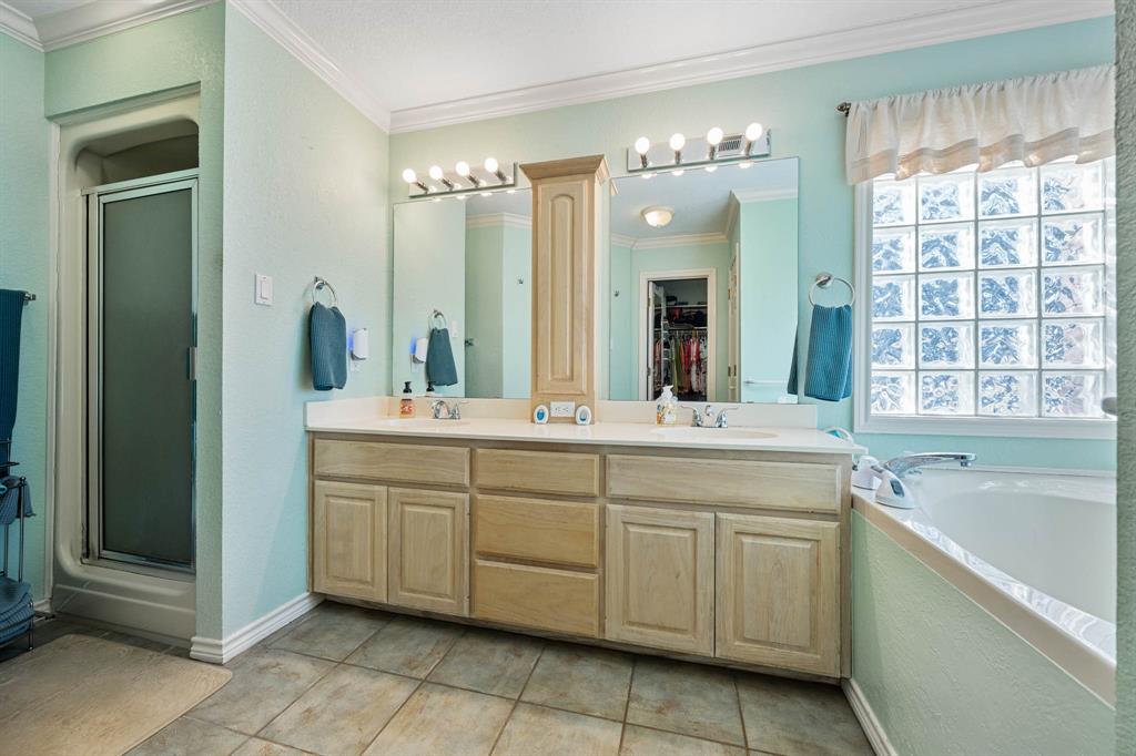 24008 Oak Shadow Whitney, TX 76692 - Photo 17 of 38 a spacious bathroom with a double vanity sink a large mirror and a bathtub