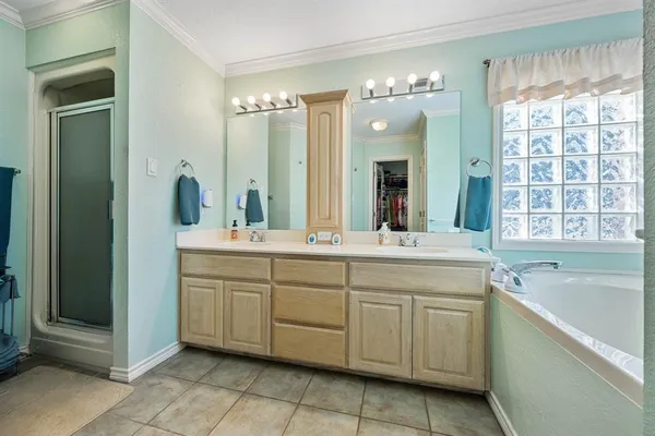 a spacious bathroom with a double vanity sink a large mirror and a bathtub