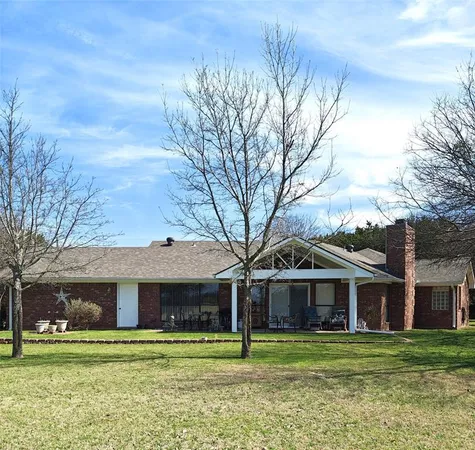 a big white house with a big yard and large trees