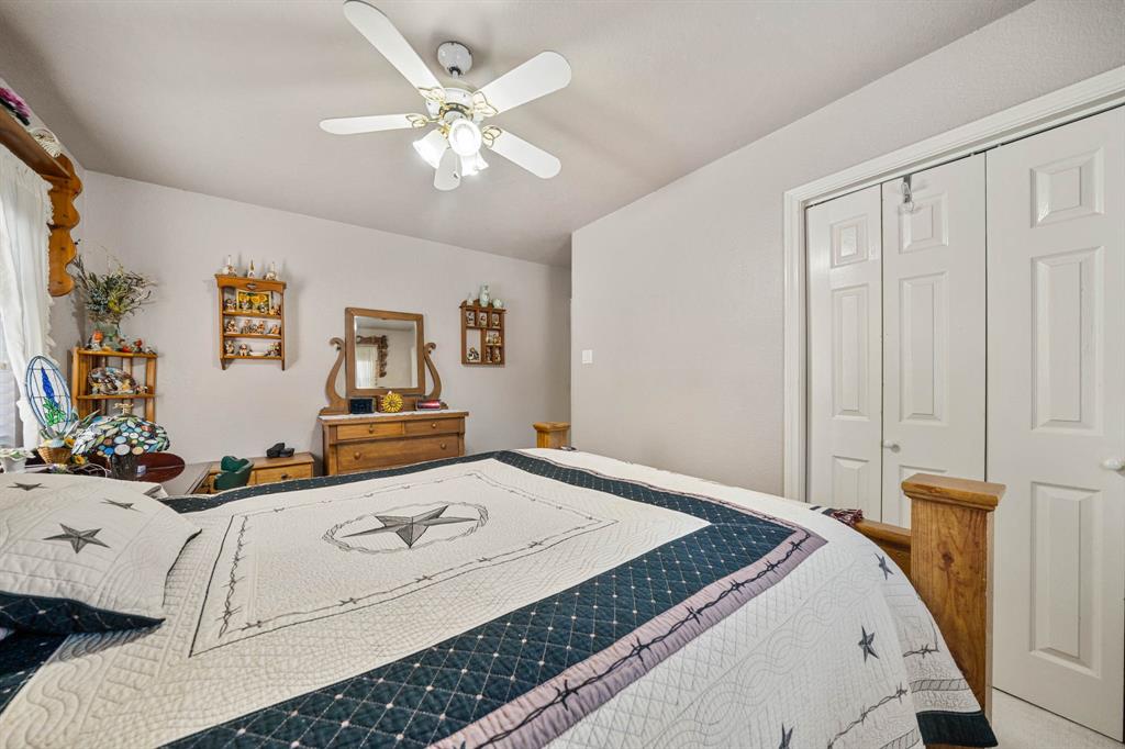 24008 Oak Shadow Whitney, TX 76692 - Photo 21 of 38 a bedroom with a bed and a chandelier