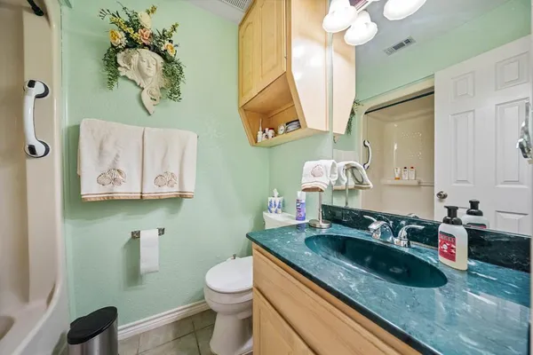 a bathroom with a granite countertop sink a toilet and a mirror