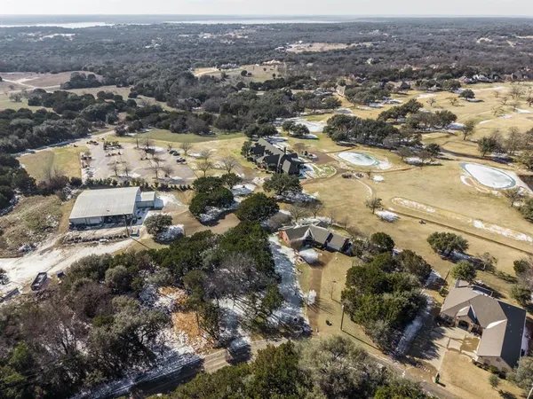 an aerial view of residential houses with outdoor space and trees