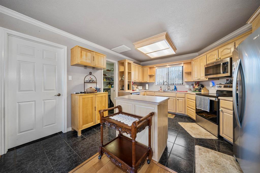 24008 Oak Shadow Whitney, TX 76692 - Photo 10 of 38 a kitchen with stainless steel appliances granite countertop a refrigerator a stove and a sink with dishwasher next to a window