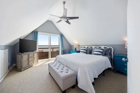 a spacious bedroom with a bed and a flat screen tv