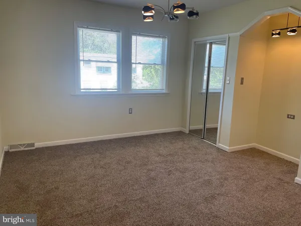 an empty room with windows and closet