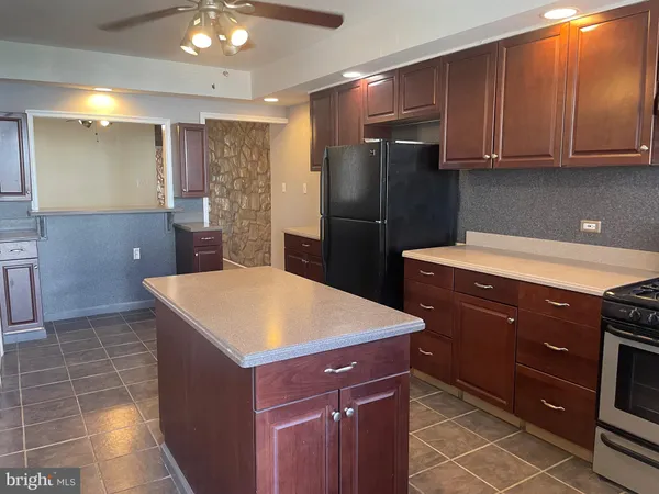 a kitchen with a sink a refrigerator and cabinets