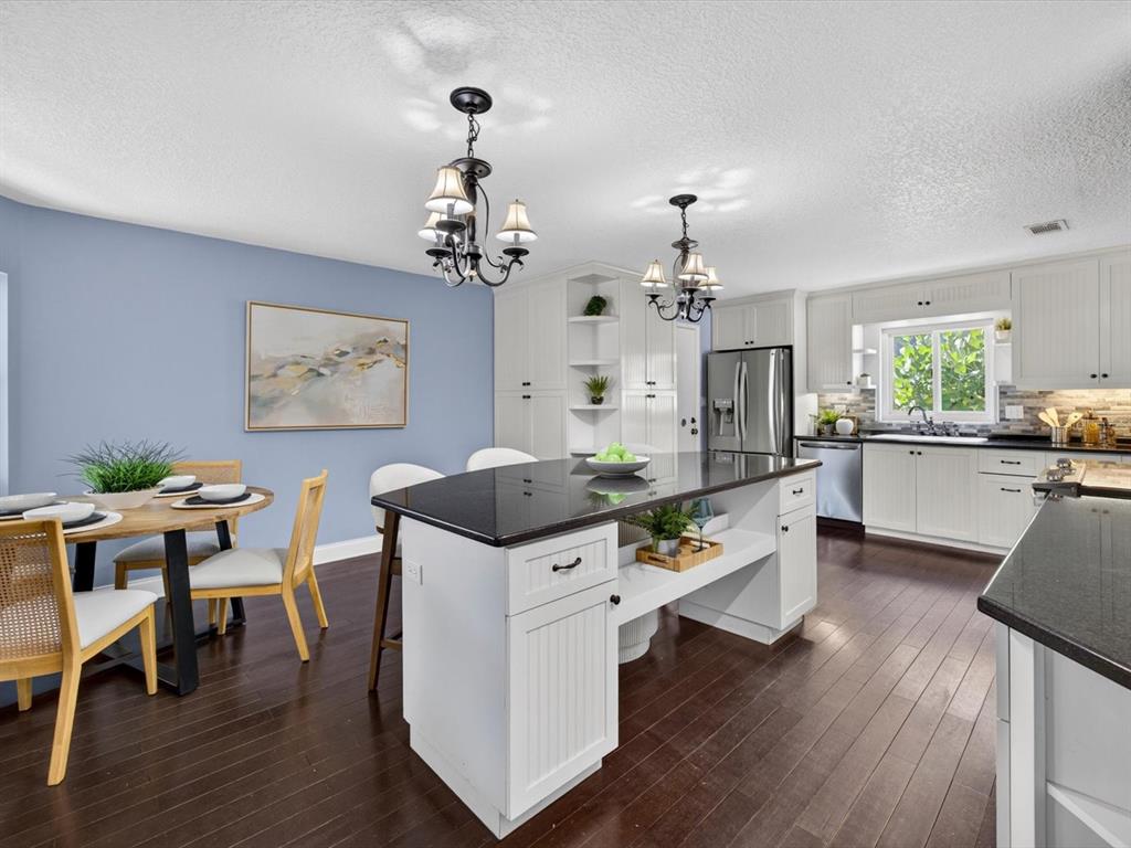 333 Cornwall Road Winter Park, FL 32792 - Photo 8 of 32 a living room with dining table wooden floor and a chandelier