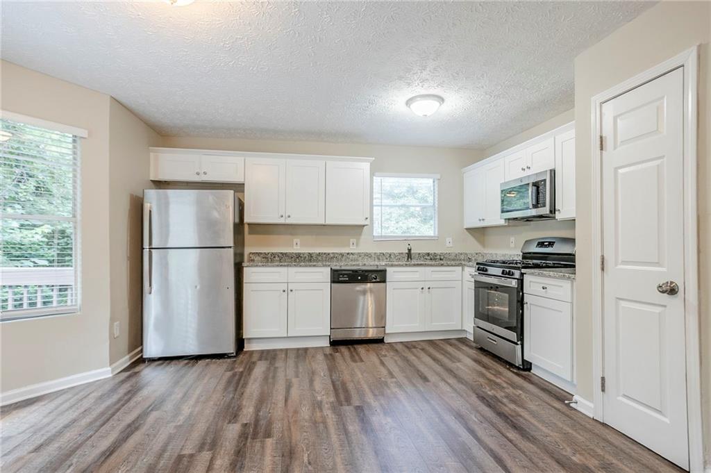 3822 Conley Downs Lane Decatur, GA 30034 - Photo 12 of 46 a kitchen with a refrigerator stove and wooden floors