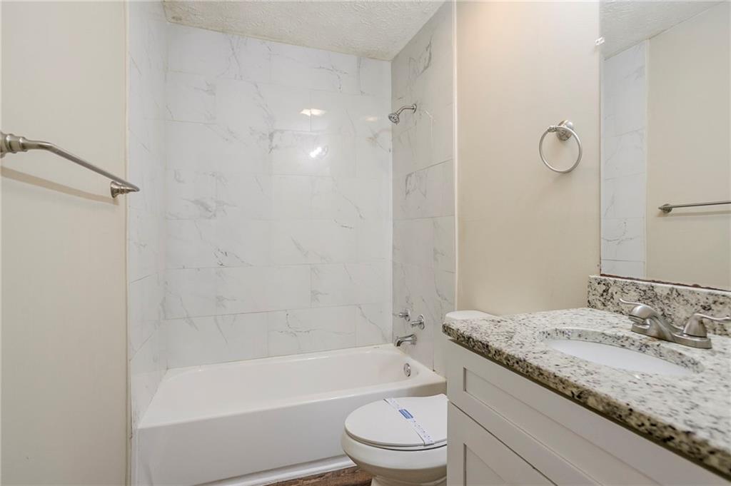 3822 Conley Downs Lane Decatur, GA 30034 - Photo 22 of 46 a bathroom with a granite countertop sink a toilet and bathtub