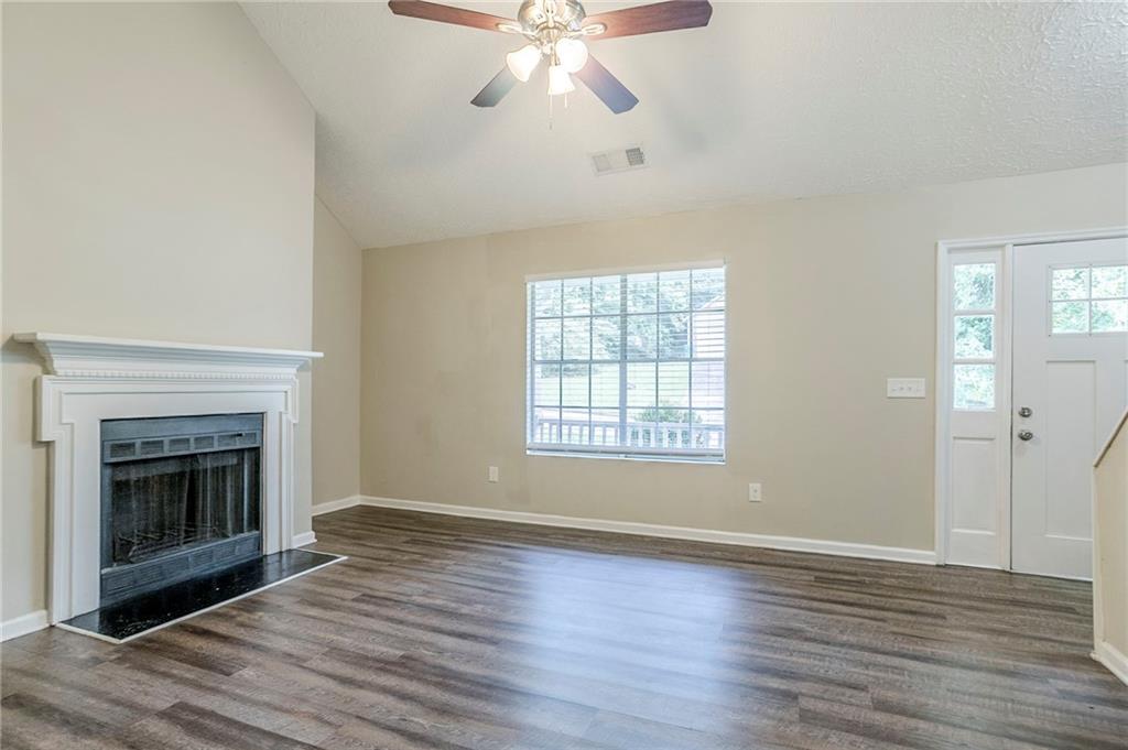 3822 Conley Downs Lane Decatur, GA 30034 - Photo 9 of 46 an empty room with wooden floor fireplace and windows