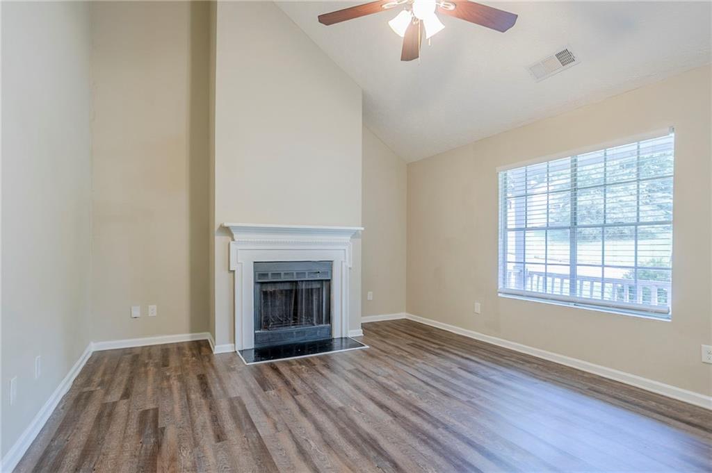 3822 Conley Downs Lane Decatur, GA 30034 - Photo 10 of 46 an empty room with wooden floor fireplace and windows