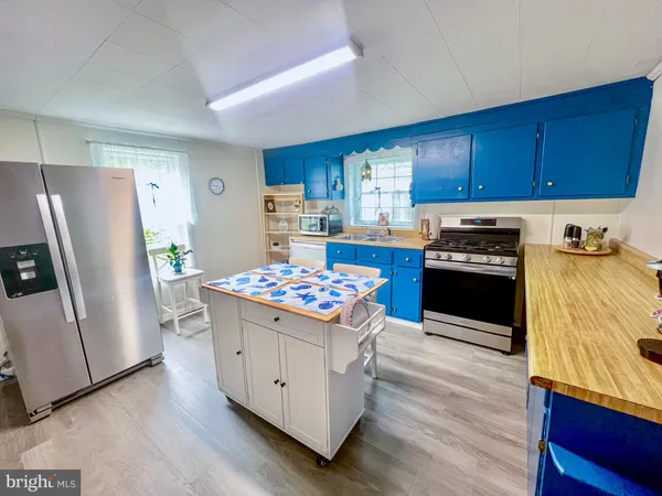 a kitchen with a stove a refrigerator and a stove top oven