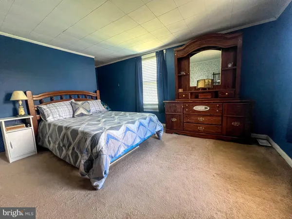 a bedroom with a bed and a mirror on dresser