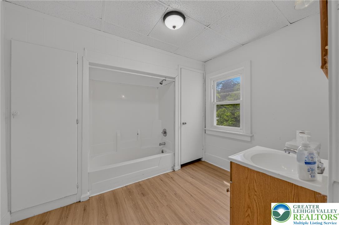 313 Main Street Slatington, PA 18080 - Photo 32 of 73 A well-maintained full bathroom offers a classic tub/shower combination, window, and a vanity with a wood cabinet.